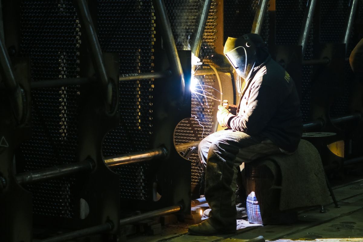 Profesional soldando una pieza en un taller industrial